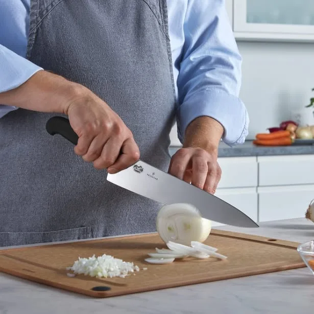 קטגוריית סכינים מקצועיות אדם חותך בצל עם סכין שף ויקטורינוקס