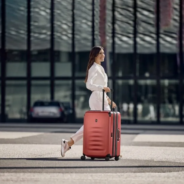 קטגוריית תיקים ומזוודות בחורה עם מזוודת SPECTRA אדומה של ויקטורינוקס